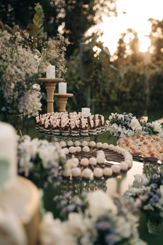 Beautifully arranged gourmet finger foods at an outdoor wedding reception in a garden setting.